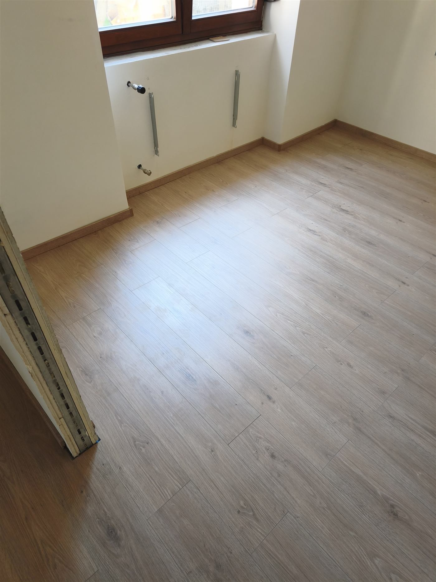 Kész laminált padló közelről, szegélyléccel